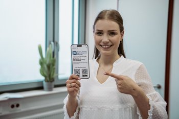 Mitarbeiterin zeigt Flyer der App